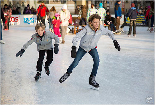 Imagem de dois meninos patinando em um ringue de patinação.